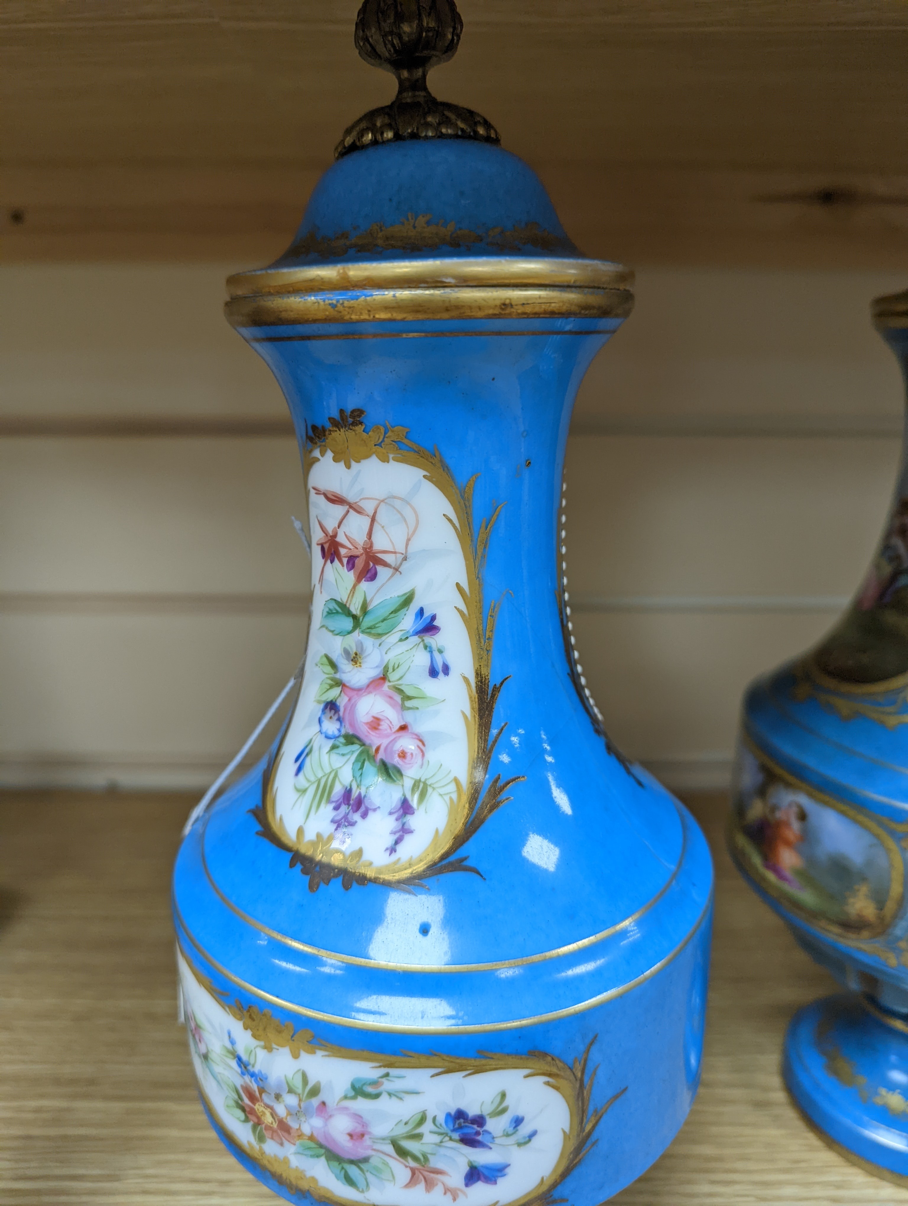 A pair of Sevres style porcelain bleu celeste ground vases and covers, 34cm